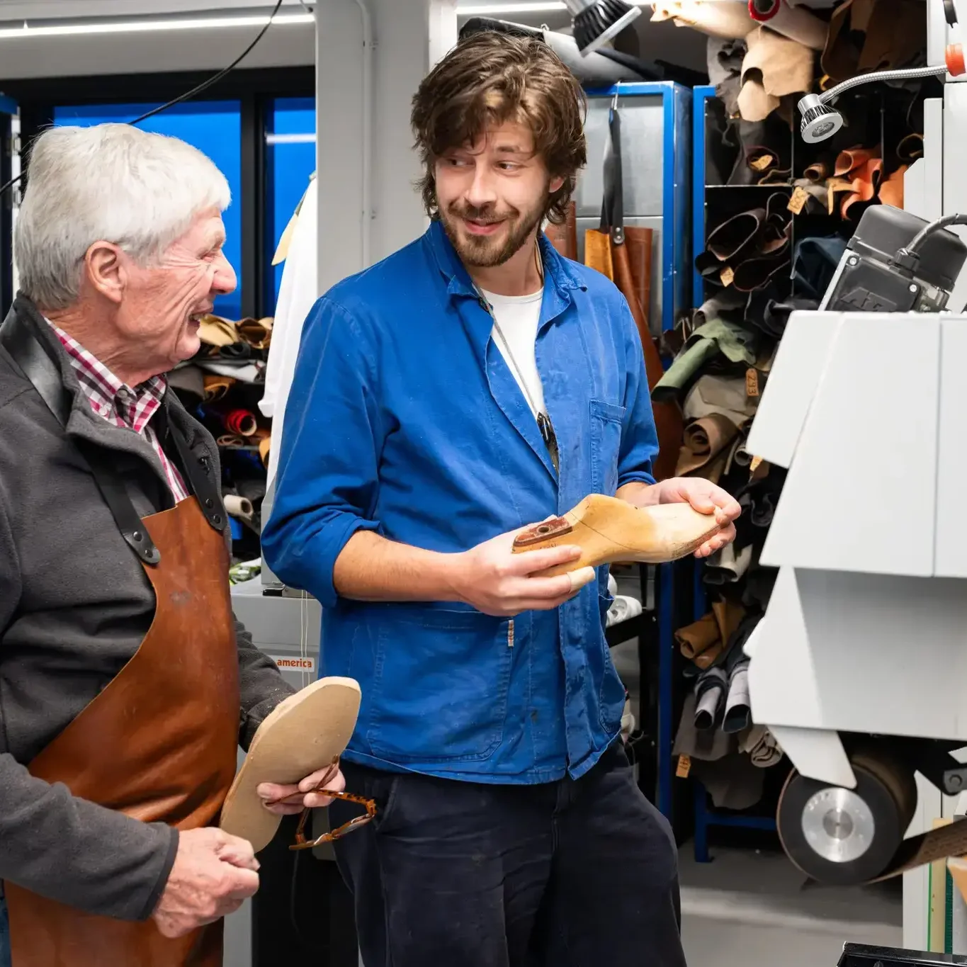 Schoenmaker in gesprek met bezoekers over ambacht en leerbewerking in het Schoenenlab.