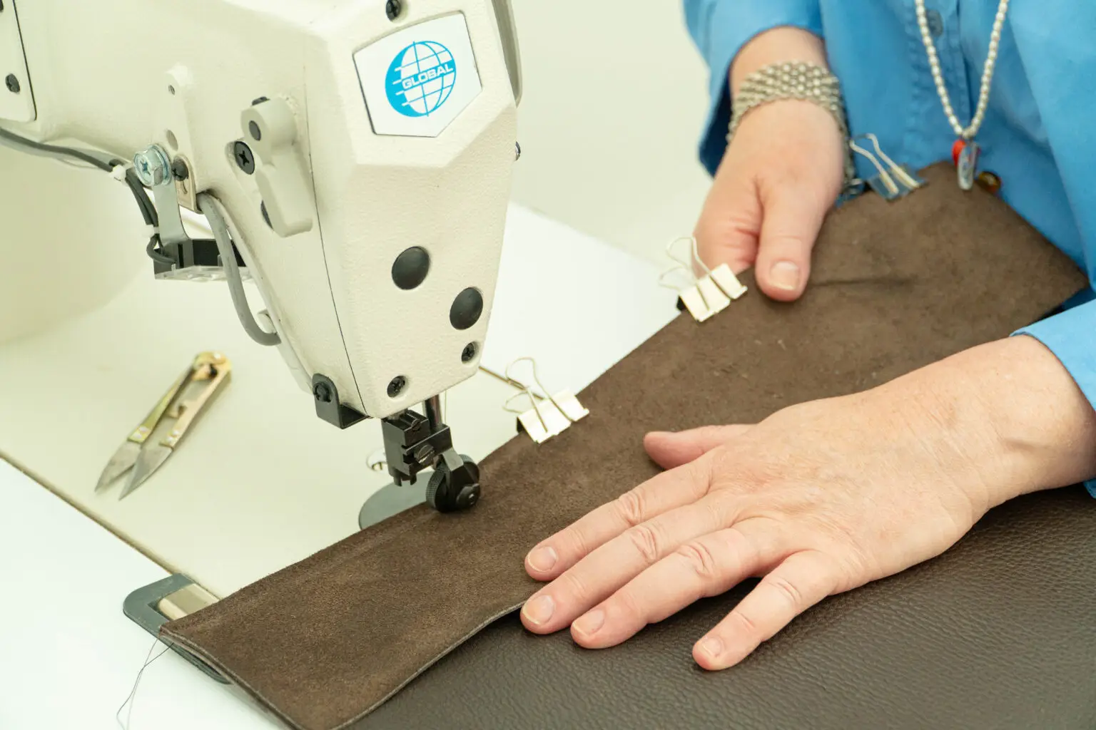 Workshopdeelnemer stikt zelf een leren tas met een naaimachine in het Schoenenlab van het Schoenenkwartier
