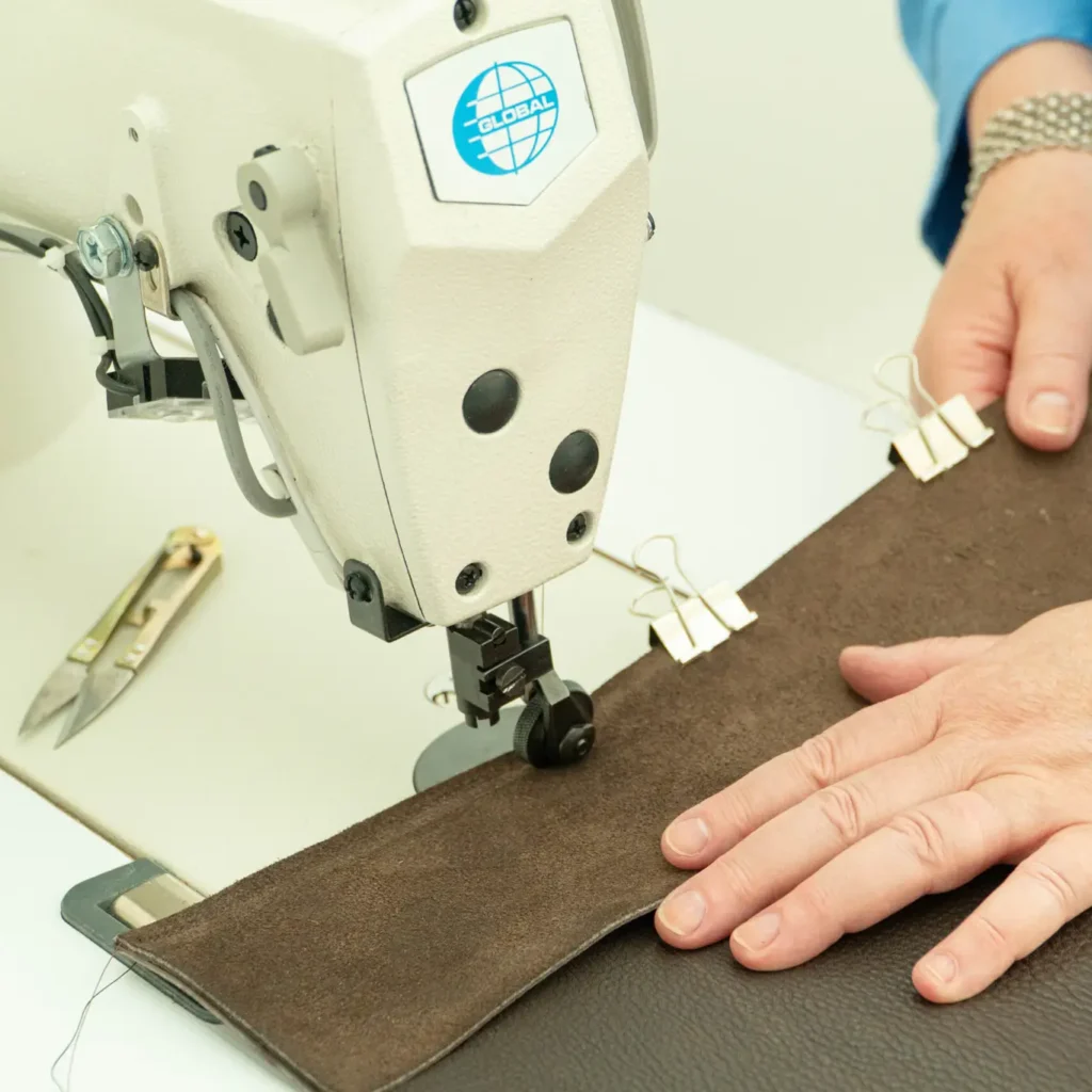 Workshopdeelnemer stikt zelf een leren tas met een naaimachine in het Schoenenlab van het Schoenenkwartier