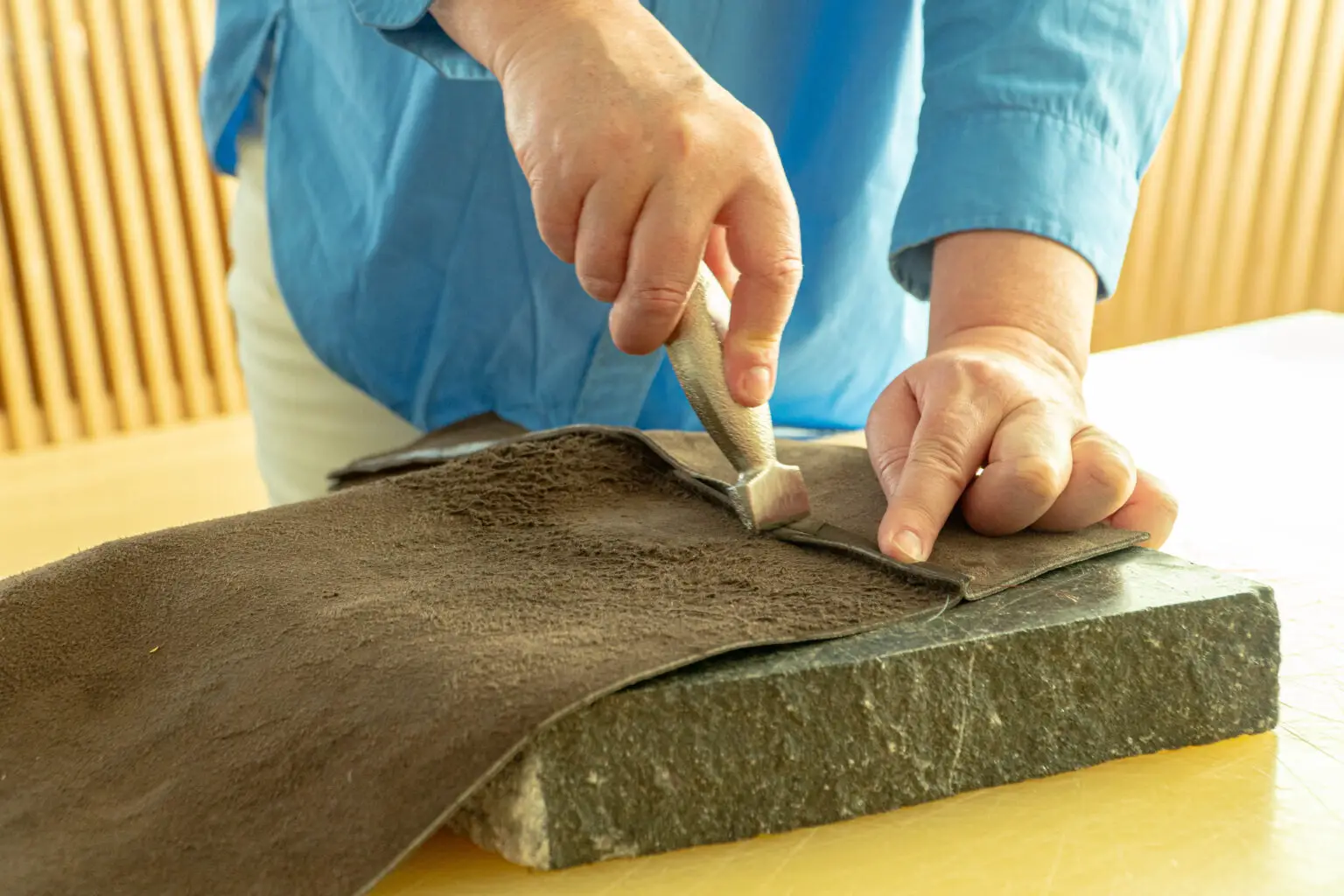 Workshopdeelnemer maakt zelf een leren tas met een naaimachine in het Schoenenlab van het Schoenenkwartier