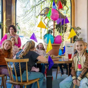 Children celebrate a birthday with lemonade, gift and decorations in the museum café during the children's party in the Shoe Quarter