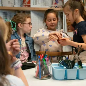 Children tinker with professional tools to see their bracelets they made during a workshop held during the Children's Festival in the Shoe Quarter
