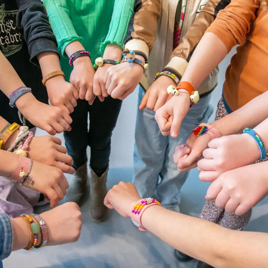 Children proudly display their bracelets they made during a workshop held during the children's festival in the Shoe Quarter
