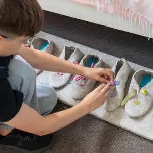 Bezoeker leert spelenderwijs schoen sluitingen zoals een gesp, klittenband en meer tijdens het Grand Hotel in de zomervakantie bij het Schoenenkwartier