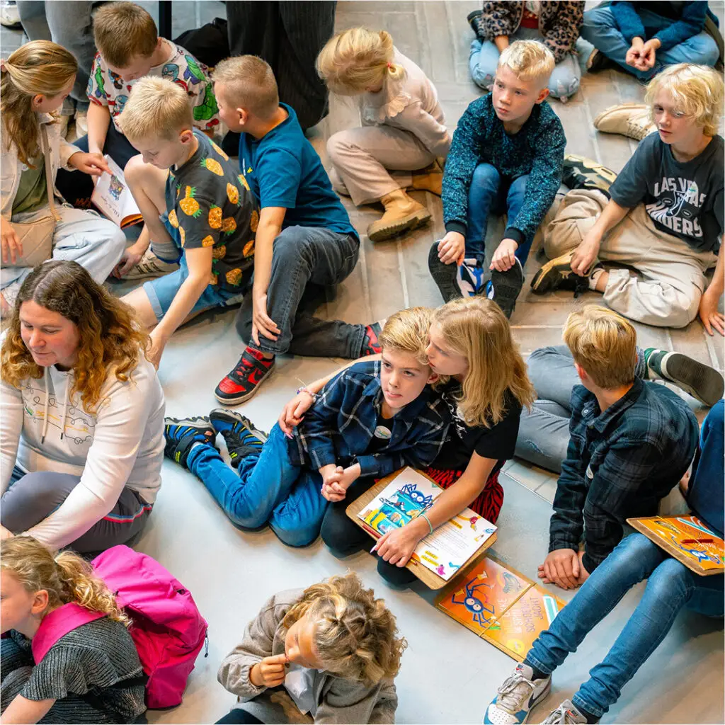 Kinderen in het atrium van het Schoenenkwartier met een speurtochtplattegrond tijdens hun museumbezoek