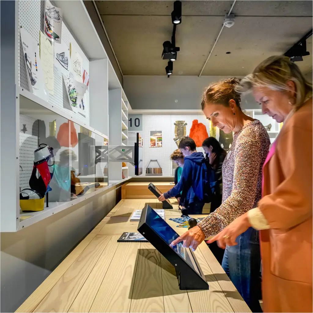 Children and adults interact to design their own shoes on the Shoe Quarter screens in the exhibition
