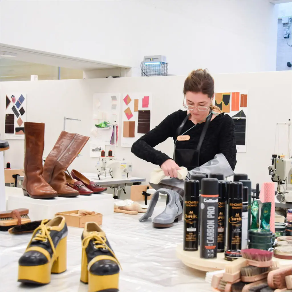 Werktafel met schoenonderdelen, leer en verzorgingsproducten in het Schoenenlab.