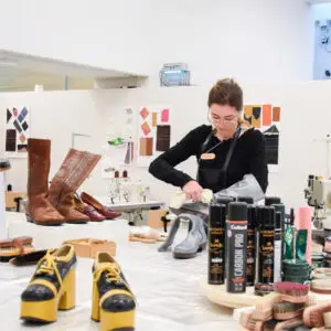 Werktafel met schoenonderdelen, leer en verzorgingsproducten in het Schoenenlab.