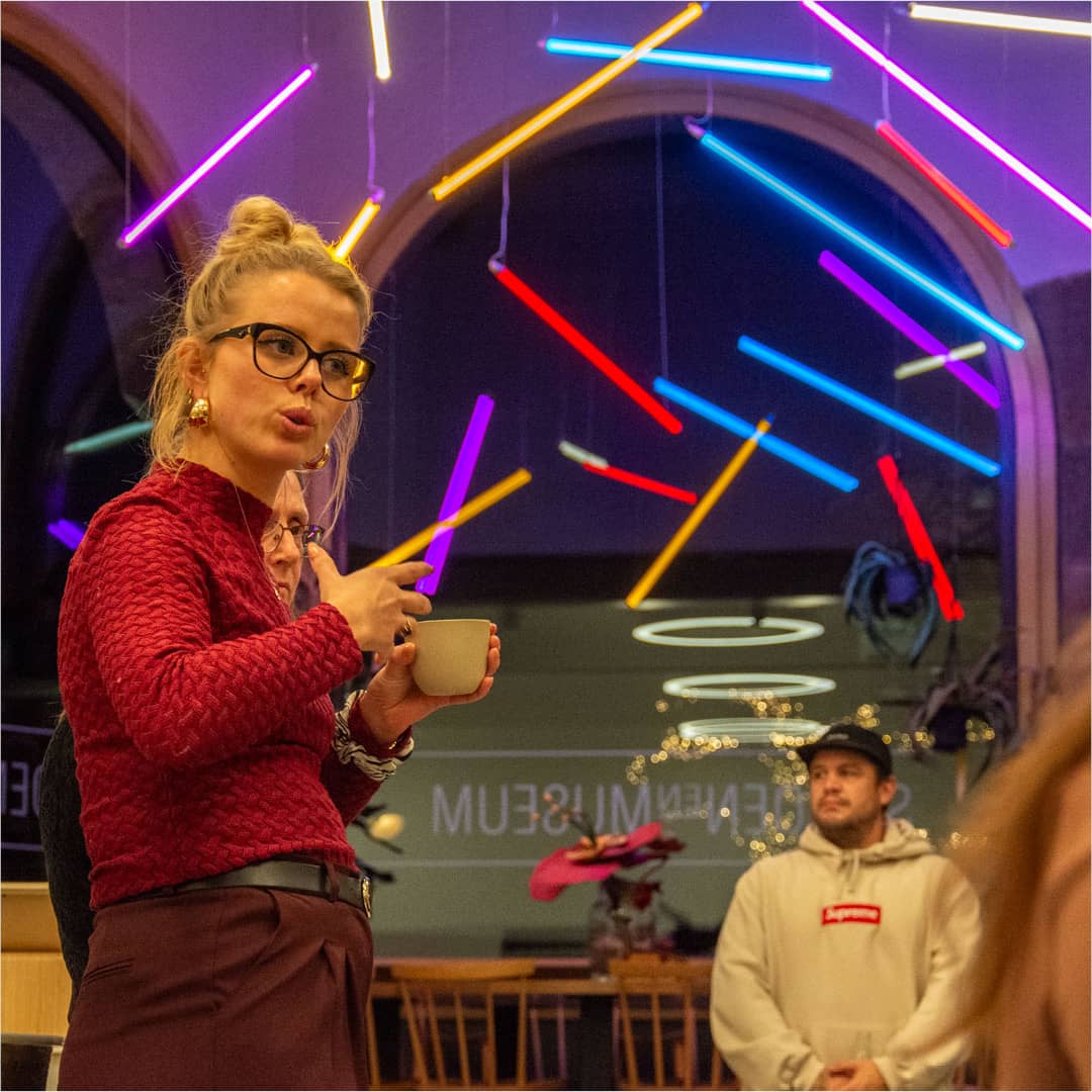 Docent van Club Zien presenteert concept in het museumcafé