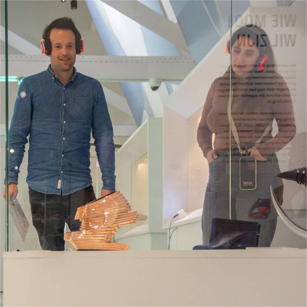 Jong volwassen bezoekers bekijken collectie in de tentoonstelling gemaakt door Zaha Hadid