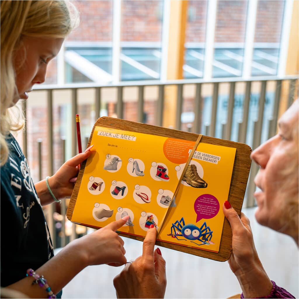 Ouder en kind zoeken schoentjes tijdens de speurtocht van Okke de Spin in het Schoenenkwartier