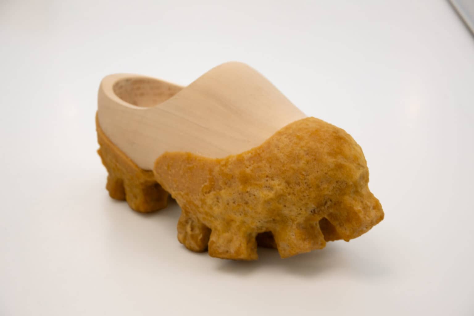 Een houten klomp gecombineerd met geel-oranje crêperubber, onderdeel van het materiaalonderzoek van Wataru Sato tijdens zijn Artist in Residency in het Schoenenkwartier in Waalwijk.