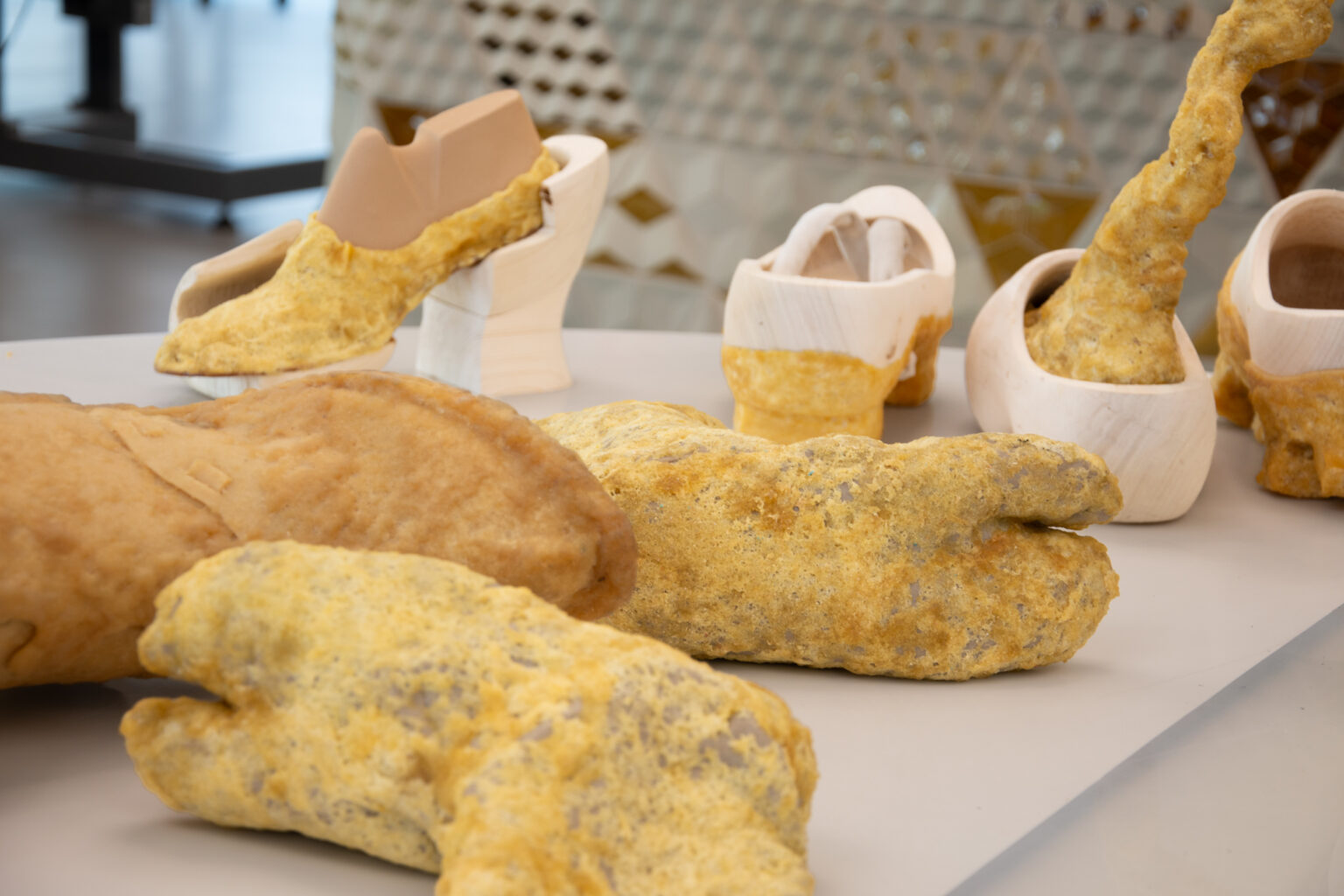 Close-up van meerdere rubberklompsculpturen met een ruwe, organische textuur, gemaakt van natuurlijk crêperubber door Wataru Sato in het Schoenenlab van het Schoenenkwartier.